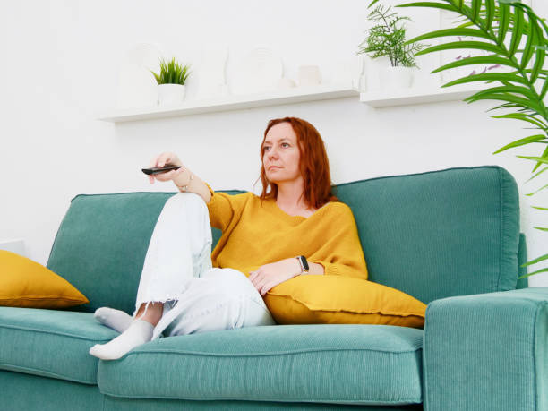 istock procrastination. Woman sitting on sofa and holding remote control. leisure and leisure activity. TV watch. watching series 2168799217