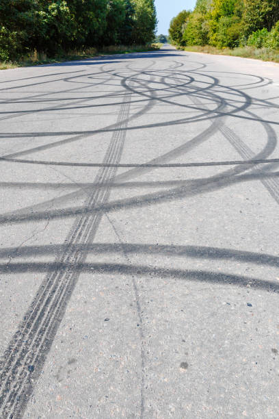 istock Skid marks on the road surface. Circular tire tracks left by drivers making donuts. Tire print on asphalt road 2168799548