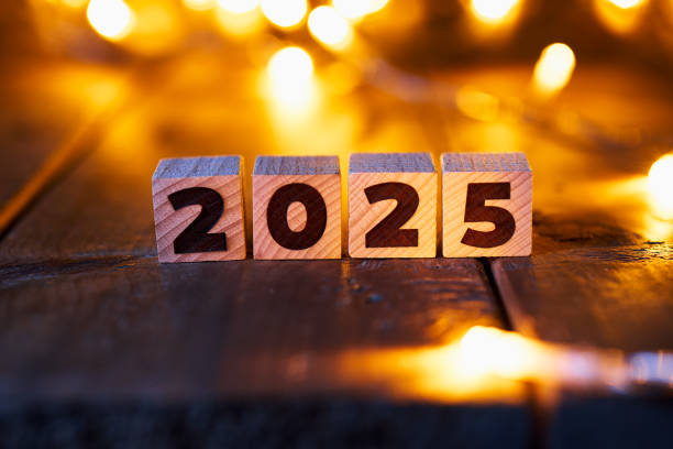 istock Wooden blocks forming the year 2025 displayed on a rustic wooden surface, with warm, softly glowing fairy lights in the background, creating a festive New Year ambiance. 2168800855