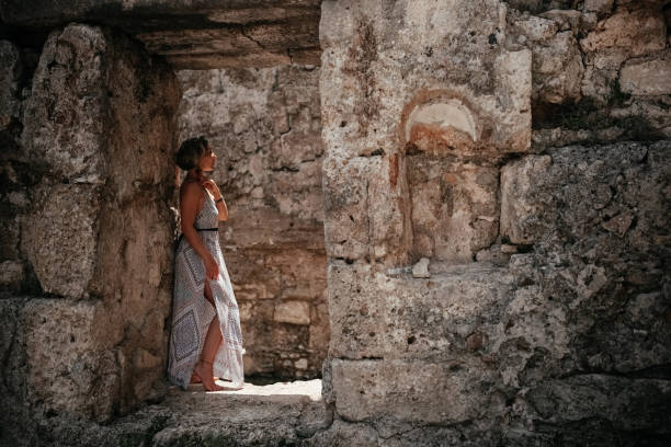istock Woman standing in ancient ruins under sunlight in a serene outdoor setting 2168802950