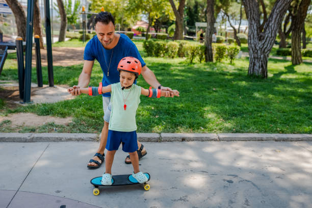 istock Father teaching his son how to skateboard 2168807360