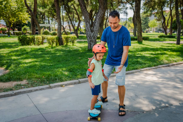 istock Father teaching his son how to skateboard 2168807365