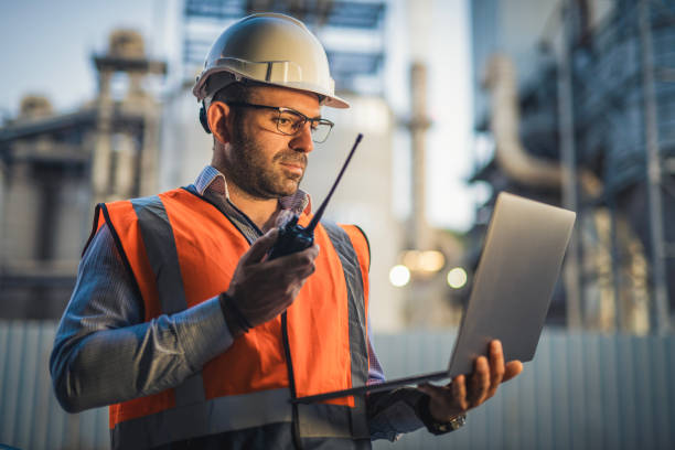 istock Engineer using technology and talking on walkie talkie during working on power line in field. 2168809181