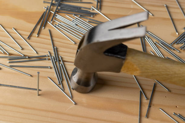 istock nails with small caps and an iron hammer on boards 2168809759