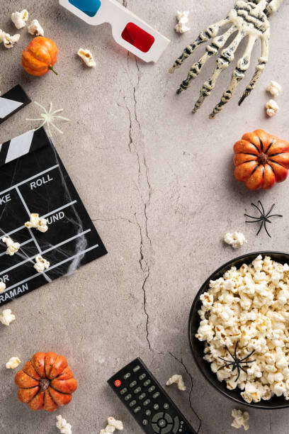 istock Halloween-themed vertical setting with popcorn, pumpkins, and spooky decorations for a horror movie night 2168812009