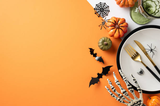 istock Halloween table setting featuring pumpkins, spider webs, a skeleton hand, and bat decorations for a festive atmosphere 2168812032