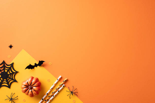 istock Halloween themed image featuring a small pumpkin, bats, spider web, and spiders on an orange background, ideal for festive designs 2168812100