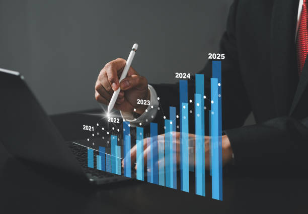 istock Businessman sits with pen touching virtual screen, annual financial report, chart with annual statistics, company progress and growth by 2025. 2168813764