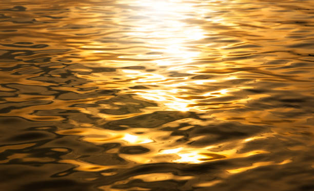 Beautiful sunlight reflection of gold water. moonlight reflection. surface​ gold​ water background. abstract golden textured background.