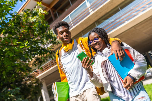 istock African couple embracing while using phone in the university campus 2168821451