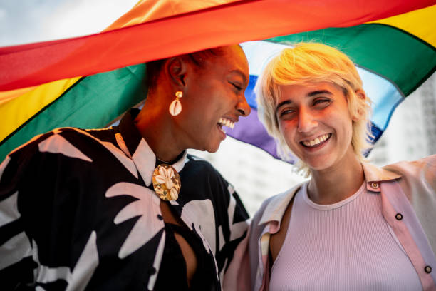 istock Lesbian couple face to face with rainbow flag on background 2168822402