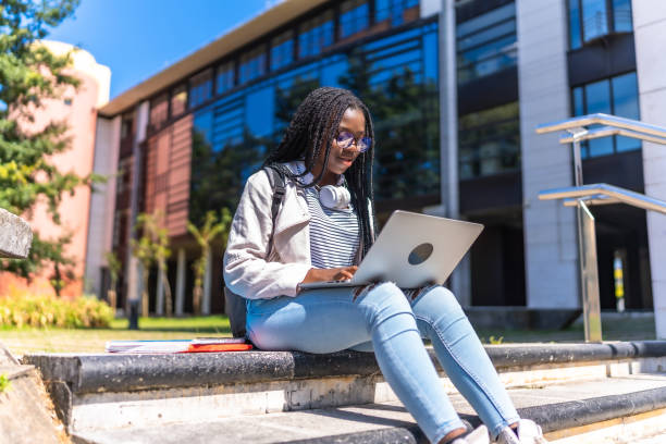 istock Focused african university student using laptop sitting on outdoors staircases 2168822466