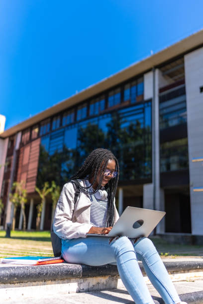 istock African young student using laptop sitting outside the campus 2168822469