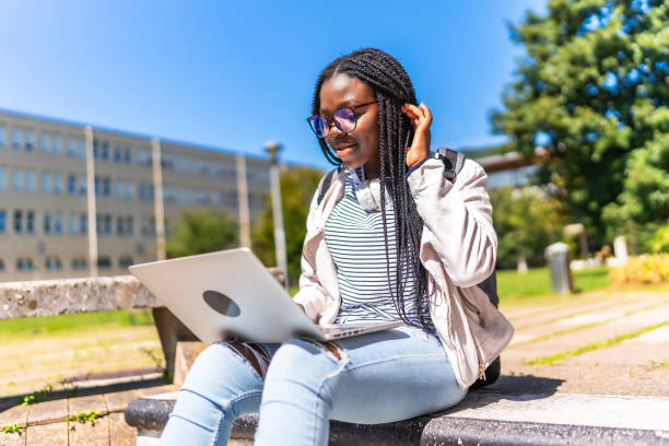 istock African student with braided hair using laptop outside the campus 2168822470