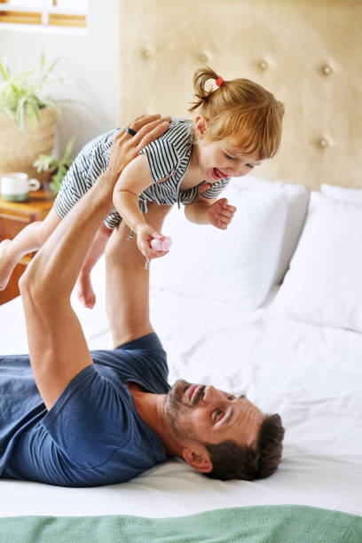 istock Father playing with daughter (18-22 months) on bed 2168833478