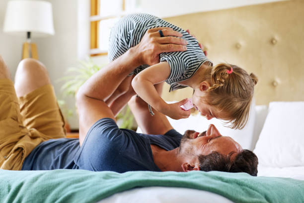 istock Father playing with daughter (18-22 months) on bed 2168833504