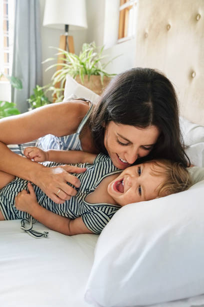 istock Mother playing with daughter (18-23 months) on bed 2168833538