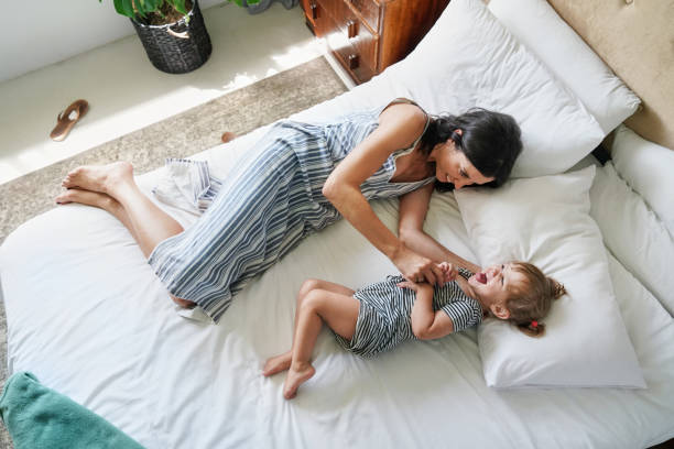 istock Mother playing with daughter (18-23 months) on bed 2168833585