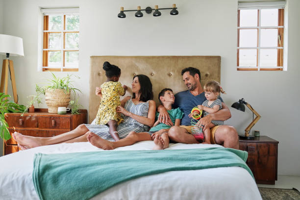 istock Parents with children (18-22 months, 6-7, 8-9) relaxing on bed 2168835884