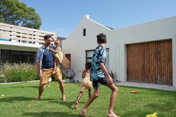 istock Father with children (18-22 months, 6-7, 8-9) playing on back yard 2168835968