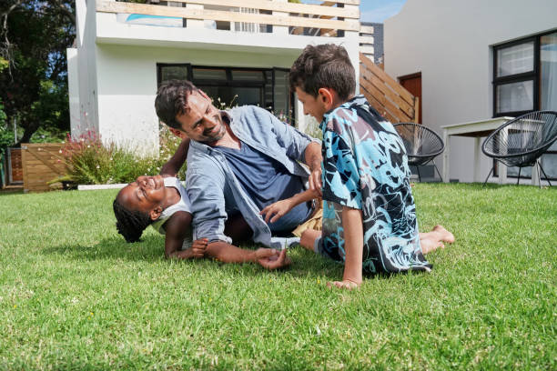 istock Father with children ( 6-7, 8-9) playing on back yard 2168836031