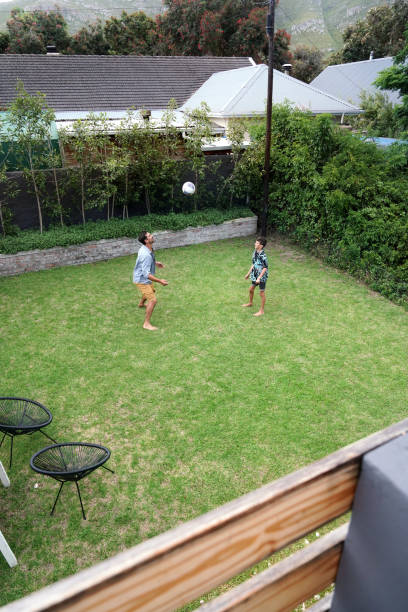 istock Father and son (8-9) playing with ball on back yard 2168837197