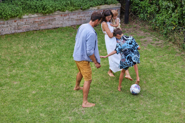 istock Parents with children (18-22 months, 8-9) playing on back yard 2168838063
