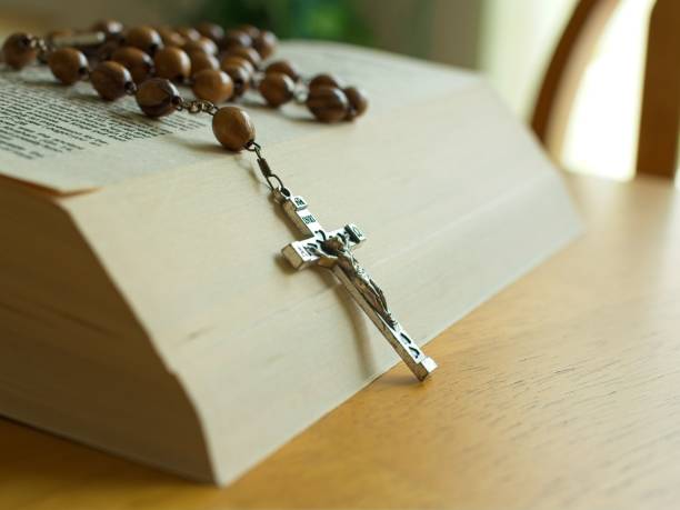 istock Rosary beads and crucifix lay across scripture text on open bible 2168840109