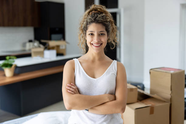 istock Happy woman moving house and smiling while packing 2168843685