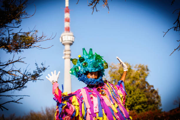 Giant poses with the Commuinications tower showing his recycled headwear. A parade and various art performances were held to promote and celebrate recycling towards saving the environment for future generations.