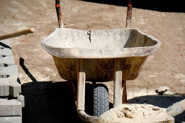 istock During paving work, a worker throws soil into a wheelbarrow with a shovel 2168863610