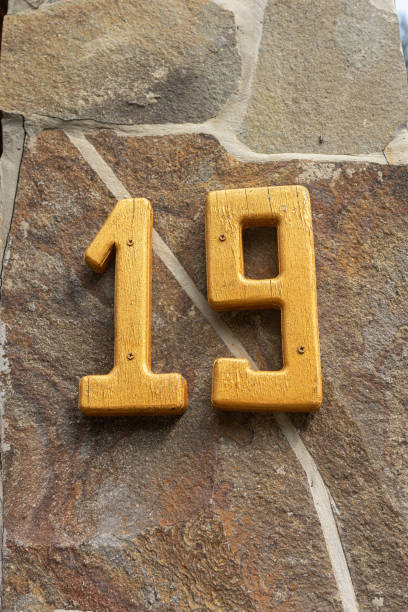 istock Yellow number nineteen on a stone wall 2168866168
