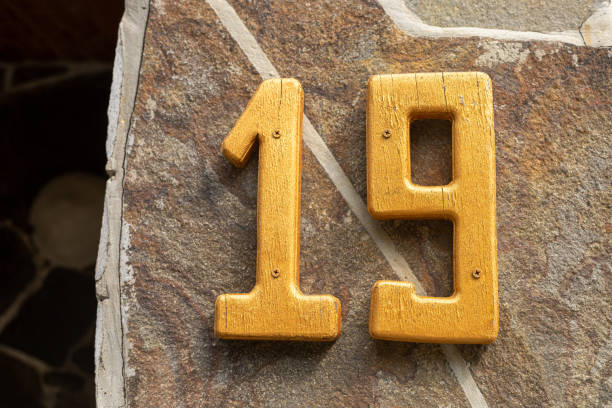 istock Yellow number nineteen on a stone wall 2168866241