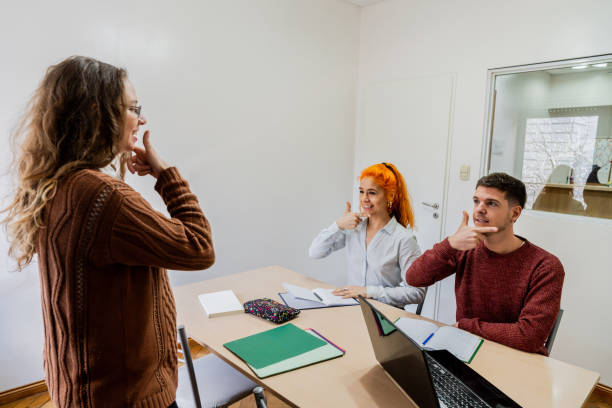 istock Young woman teaching sign language at classroom 2168866435