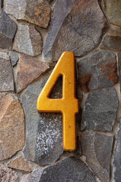 istock Yellow number four on a stone wall 2168866968