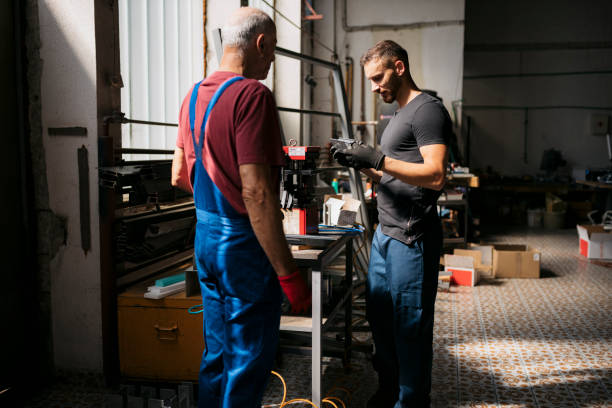istock Young employee inspecting a workpiece in workshop with senior worker 2168874533