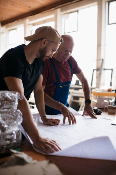 istock Two workers in a fabrication shop studying a drawing while working in the workshop 2168875085