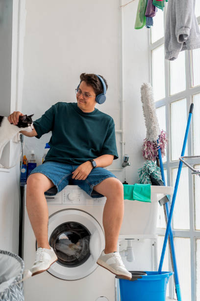 istock Man Petting Cat in Laundry Room 2168891133