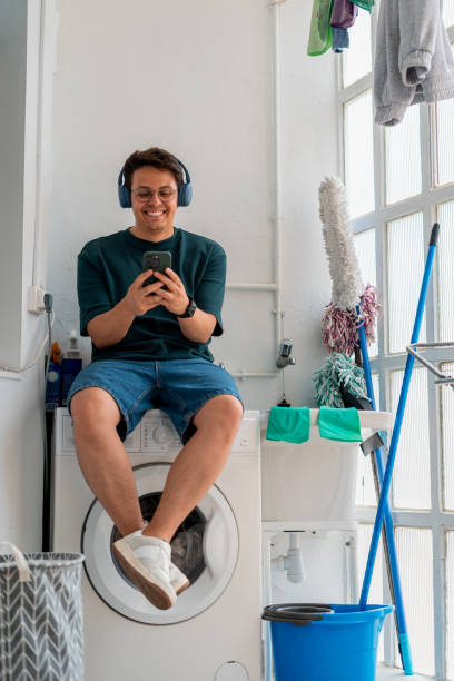 istock Man Waiting for Laundry to Finish While Using Smartphone 2168891137