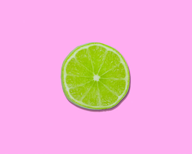 istock Green slice of lime on light pink background 2168897623