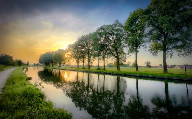 istock A Serene Sunset Reflection Gracefully Over a Canal Enveloped by Majestic Trees and Nature 2168901892