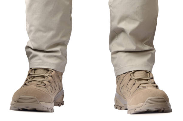 Beige tactical desert boots and durable ripstop pants, khaki tan suede leather army combat footwear pair and casual men's trousers, brand new apparel detail, large detailed isolated horizontal SOF clothing closeup, low angle feet view, white background