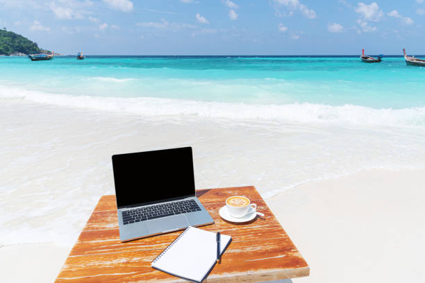 istock Mobile work office on the tropical beach with blank laptop screen 2168913303