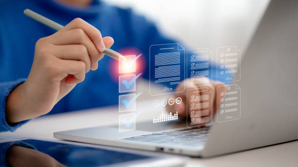 istock A businessman is using a laptop and tablet to complete online digital forms, fill out survey checklists, and assessment questionnaires as part of a business performance checklist and tracking process 2168918470