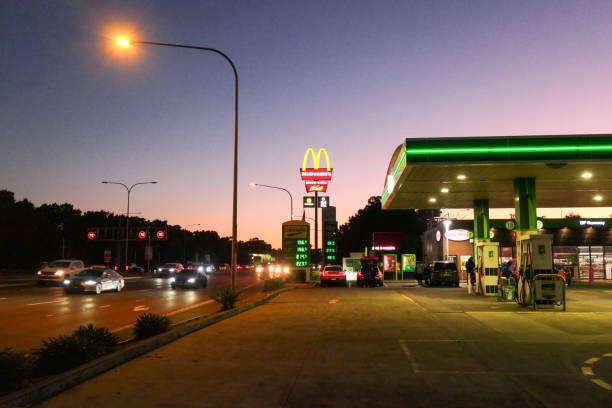 Petrol Station Sunset A British Petroleum petrol station and McDonald's restaurant on General Holmes Drive, Mascot, close to Sydney Kingsford-Smith Airport. This image faces west and was taken on a cold and sunny afternoon after sunset on 26 July 2024. speed limit sign australia stock pictures, royalty-free photos & images