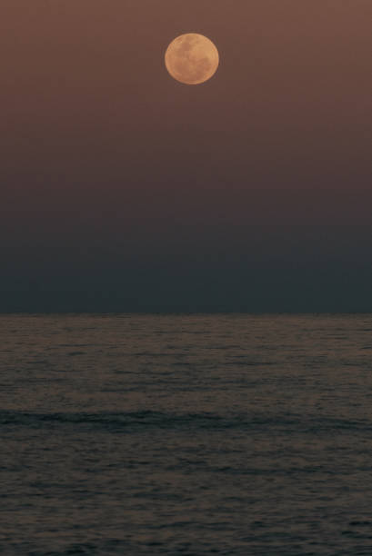 istock Full moon rising over the ocean at dusk 2168925484