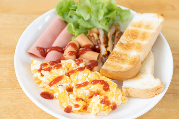 istock Gourmet Breakfast Dish: Scrambled Egg, Sausage, Ham, Bread, and Lettuce with Ketchup, A High-Energy Meal to Start Your Day 2168927169