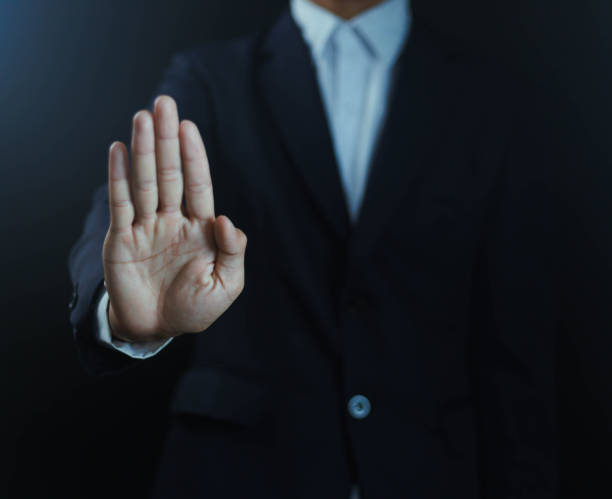 istock Image of man making a stop gesture with his palms in denial, black background 2168927188