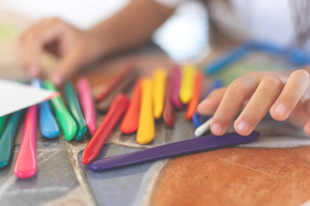 istock A child is drawing with crayons on a table 2168930111