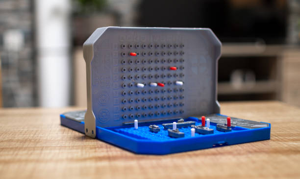A battleship game on a table indoors. Nice soft background.